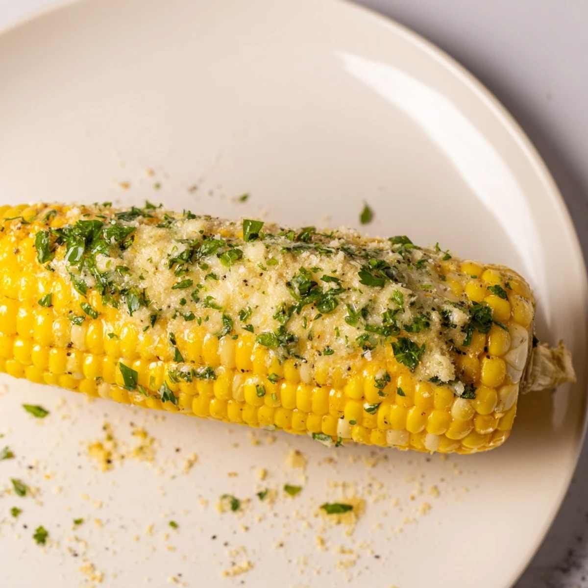 Satte, goldene Knoblauch-Butter-Maiskolben liegen angerichtet, fertig zum Verzehr, als köstliche Beilage.