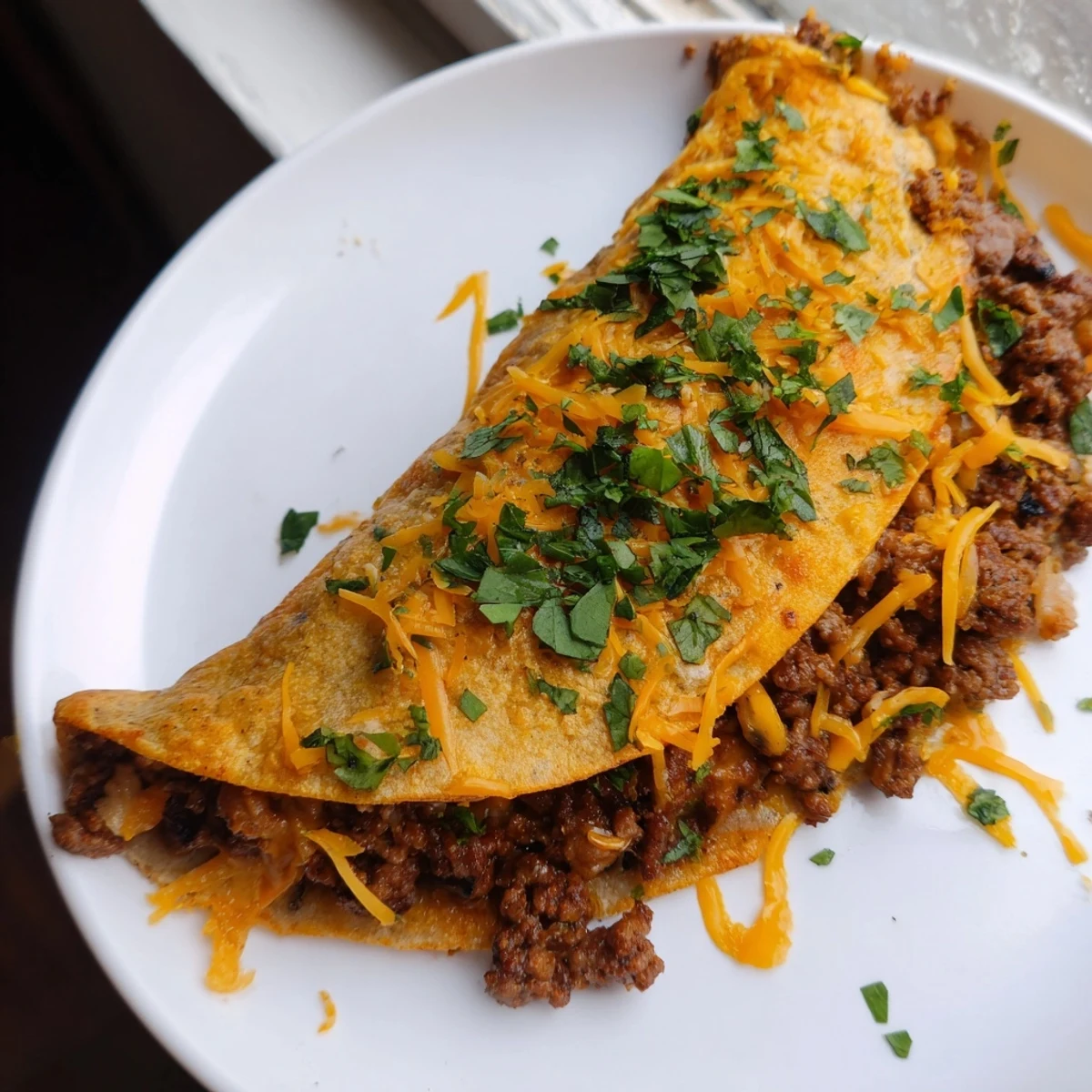 Knusprige Cheesy Beef Quesadillas mit geschmolzenem Käse, heißem Rindfleisch und frisch gehacktem Koriander serviert.