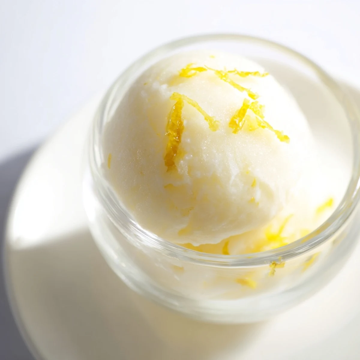 Close-up of bright yellow lemon sorbet, a smooth and delightful dessert to enjoy.