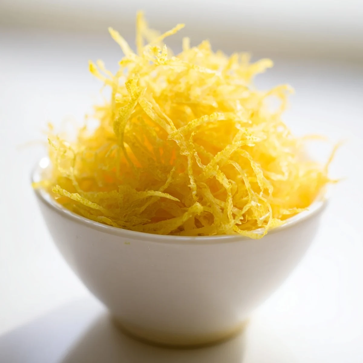 Close-up of freshly zested lemon, showing textured zest perfect for baking and cooking.