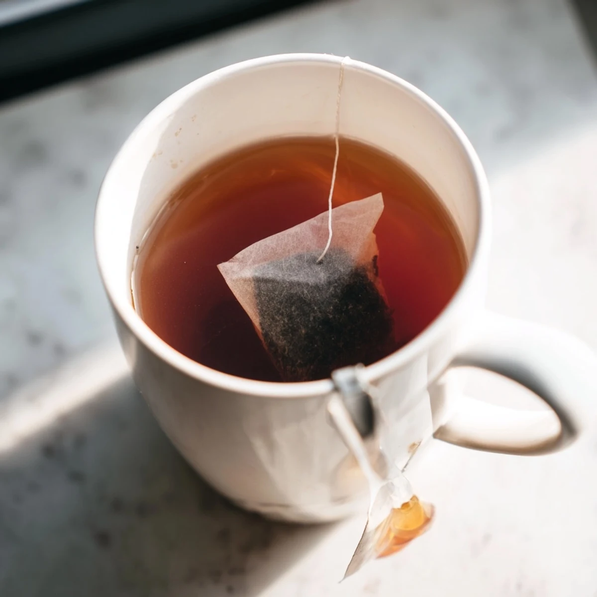 A steaming mug offering a delicate bag tea, perfect for a cozy morning or afternoon.