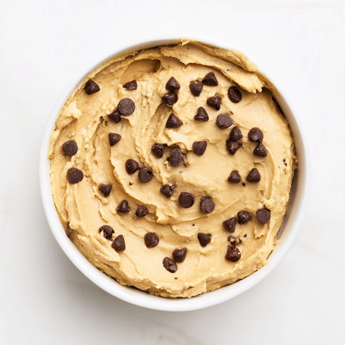 Schokoladenchip-Kuchenteig-Hummus mit frischem Obst, cremig und süß zum Eintauchen.