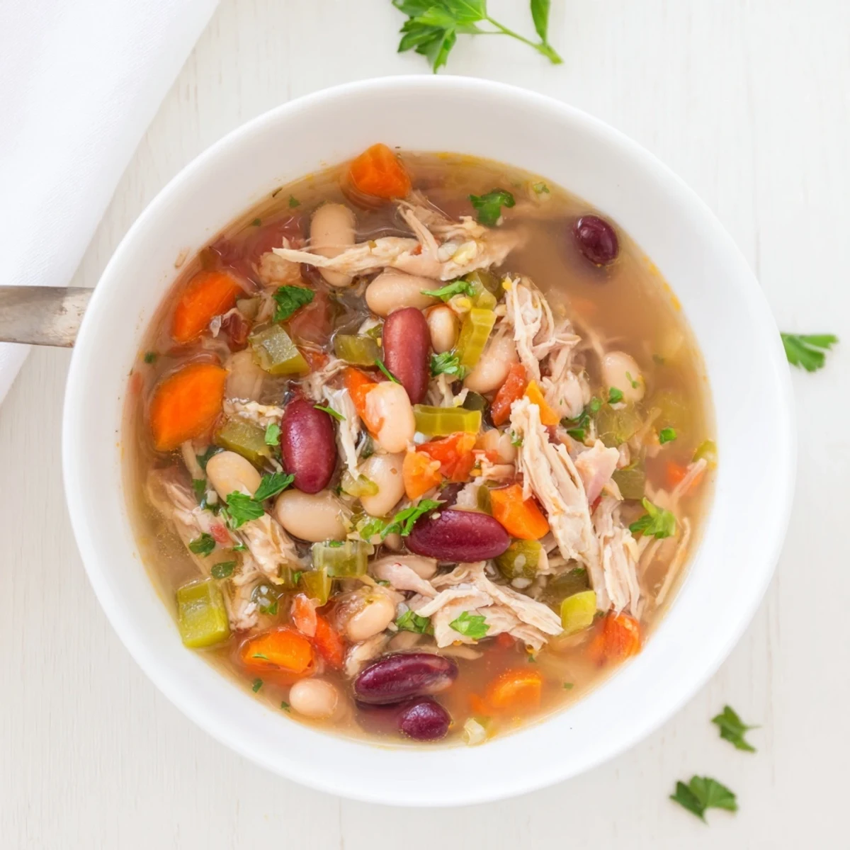 Steaming Creole Bean Soup with Turkey in a rustic bowl, featuring red and white beans.