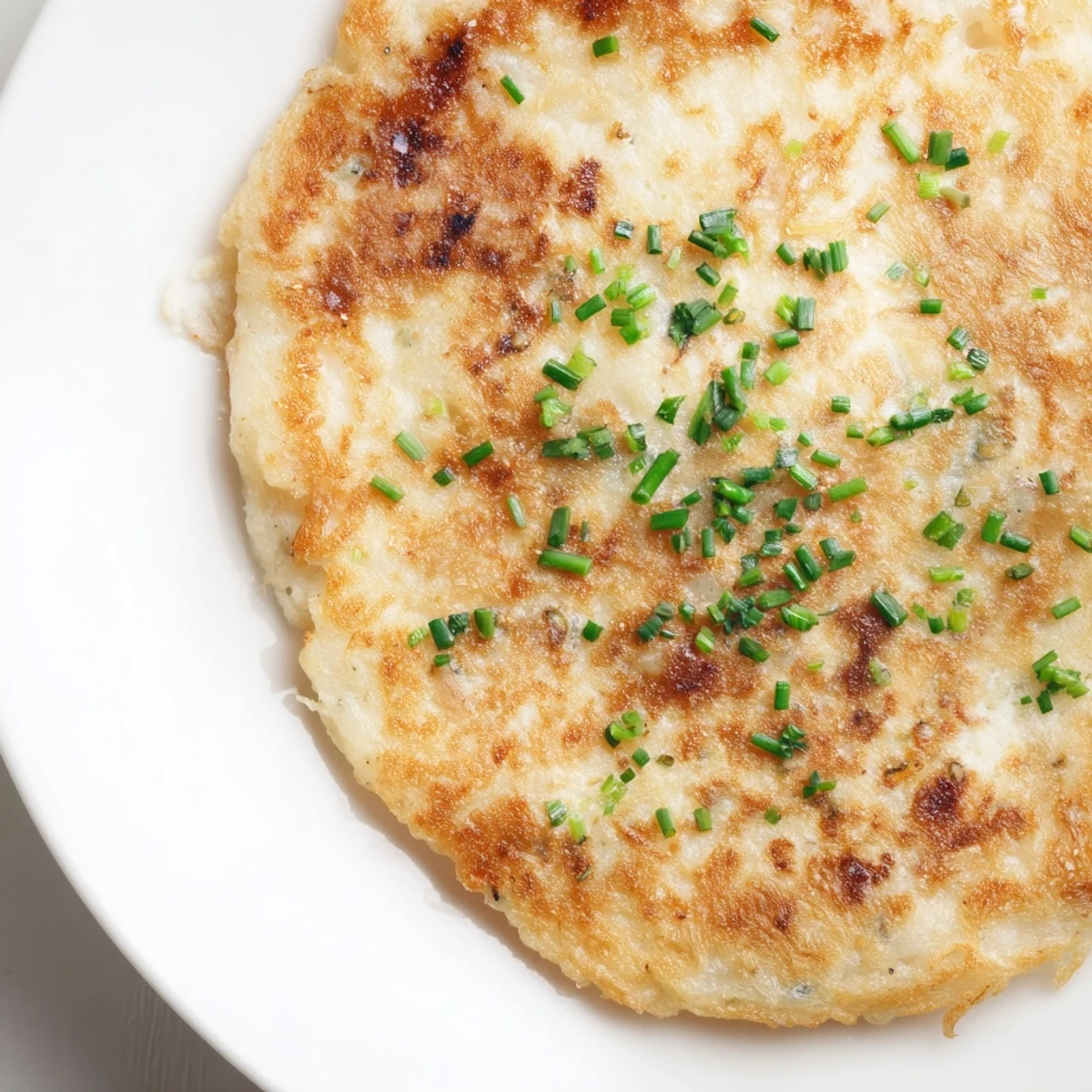Gepfefferte Irish Boxty Potato Pancakes neben einer Schale saurer Sahne und Räucherlachs zum Dippen.