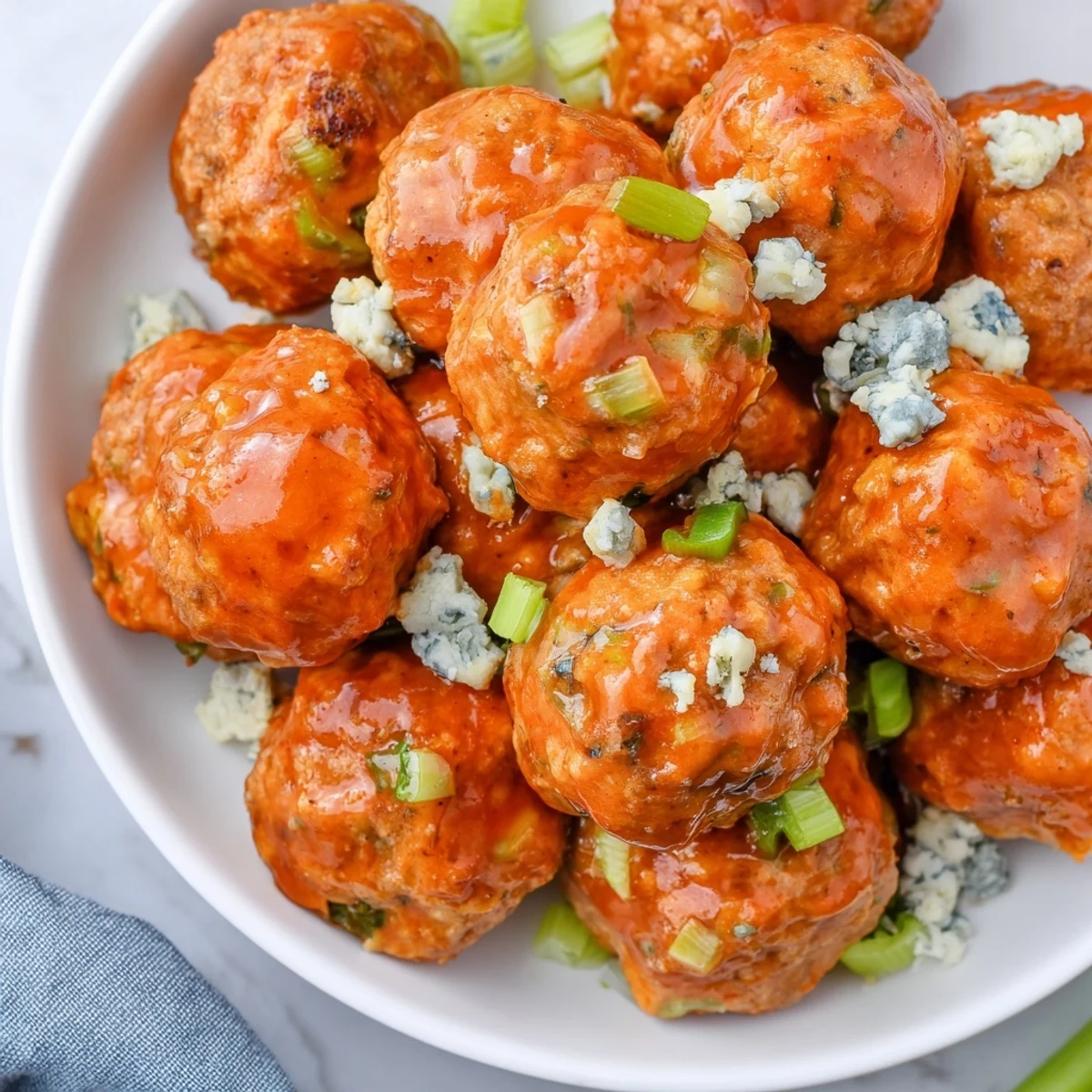 Freshly baked Touchdown Buffalo Chicken Meatballs, tender and golden, paired with crisp carrot sticks and ranch dressing on a rustic wooden board.