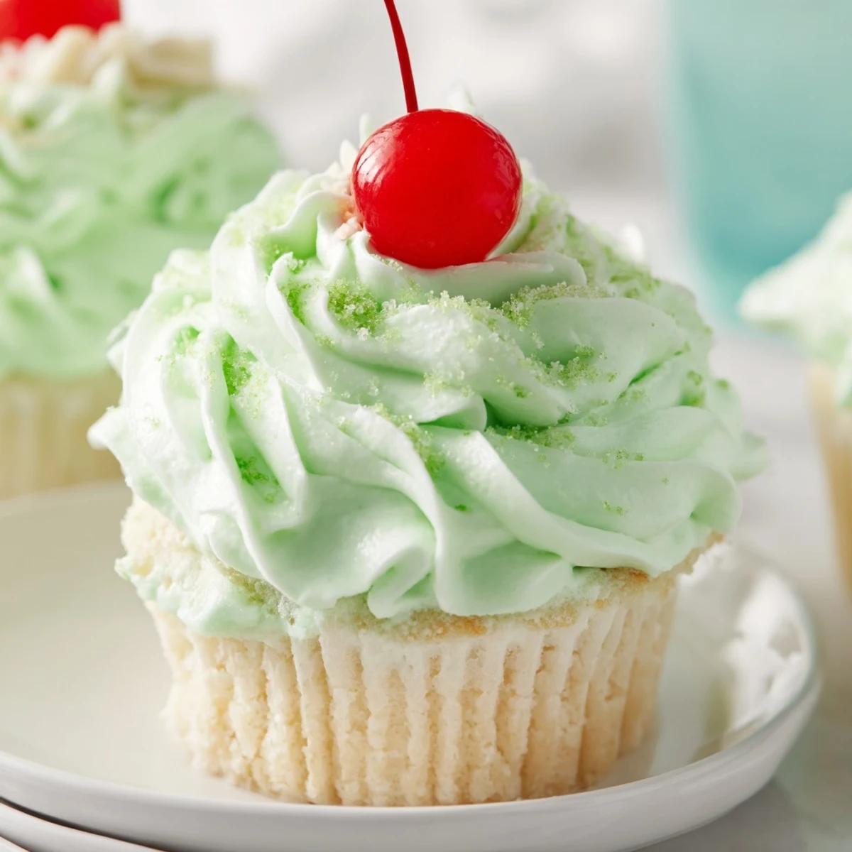 Mint-frosted Shamrock Shake Cupcakes on a marble counter ready for a St. Patrick's Day party.
