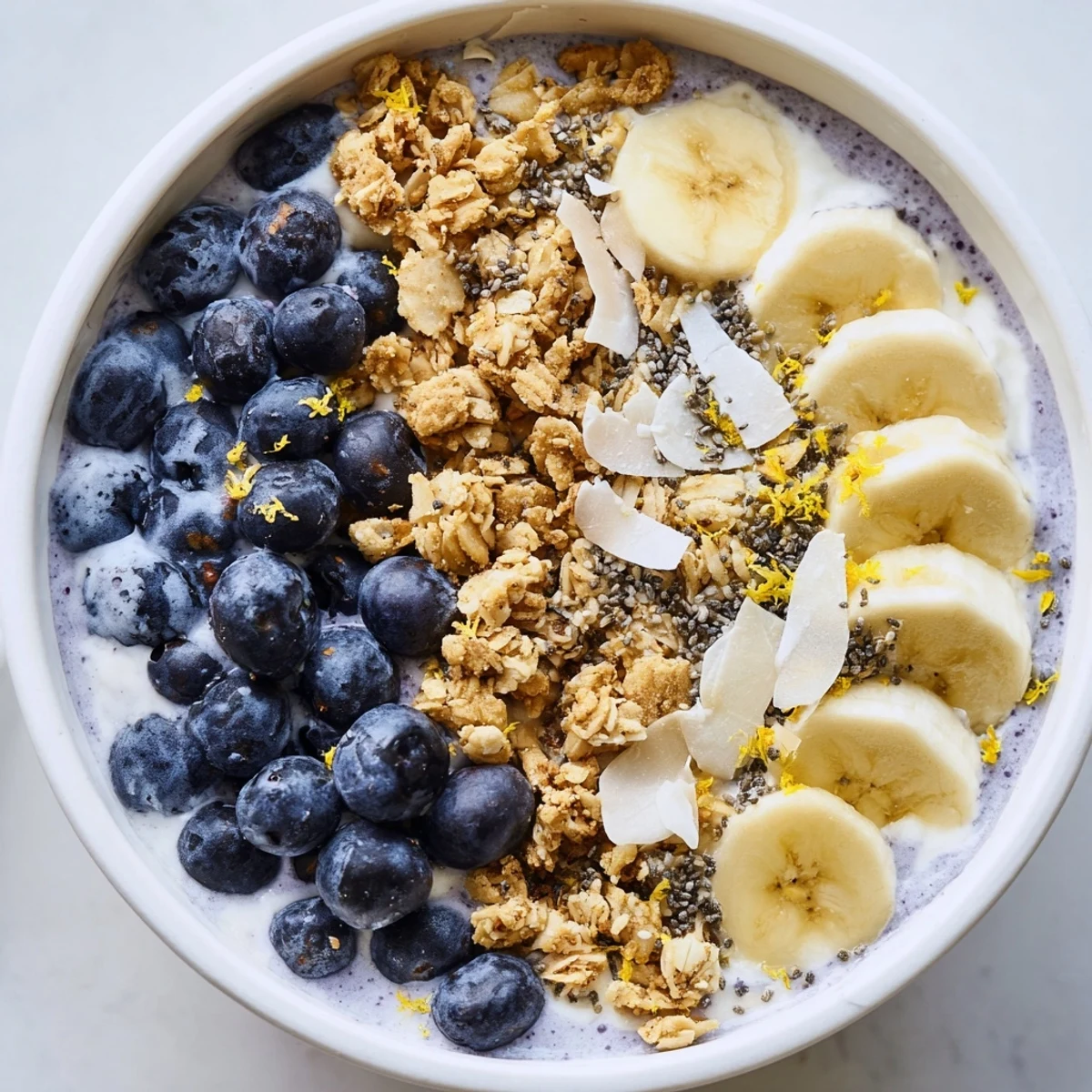 Lemon Blueberry Smoothie Bowl with Granola served in a rustic white bowl, topped with fresh blueberries and creamy Greek yogurt.