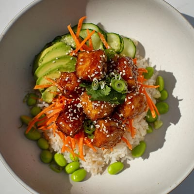 A close-up of a delicious ginger sesame tofu bowl, ready to enjoy with fresh garnish.