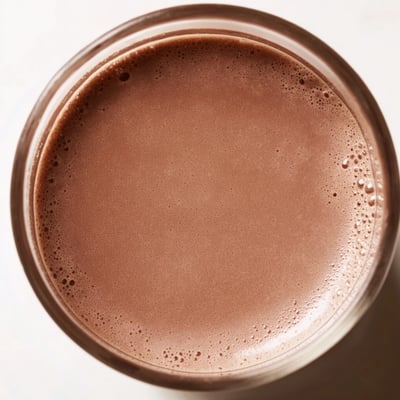 Rich chocolate milk with cocoa, steaming in a mug, perfect for warming up cold days.