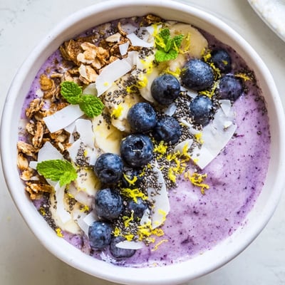 Ein leckeres, farbenfrohes Lemon Blueberry Smoothie Bowl mit Blaubeeren, Zitrusnote und knackigem Topping.